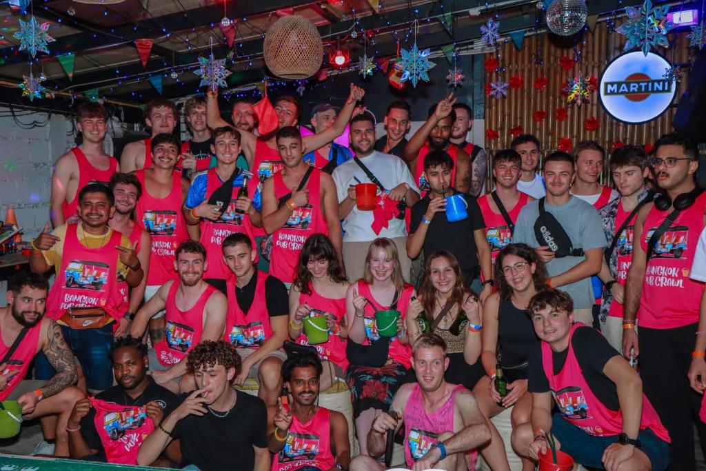 Large group of travellers with buckets at the first bar of the night